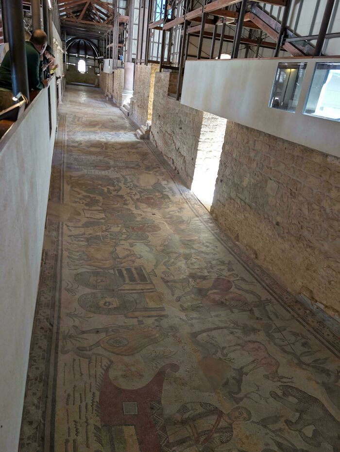 Long corridor with detailed mosaic floor in historical archaeological site