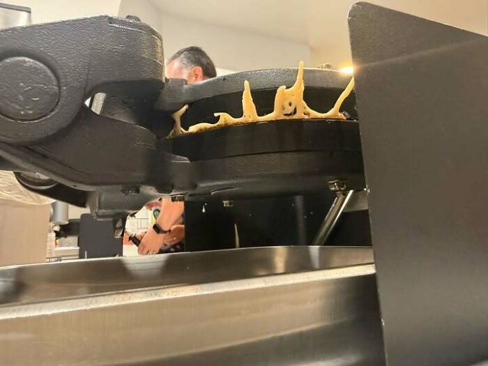 Waffle maker with batter shaped like small smiling faces appearing to stare