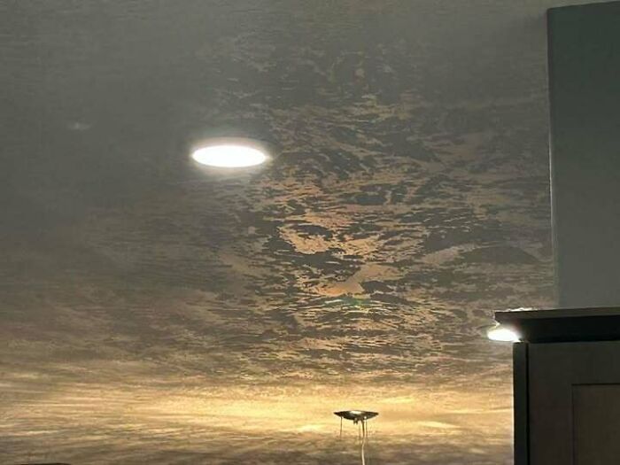 Light fixture reflection on textured ceiling staring like eyes