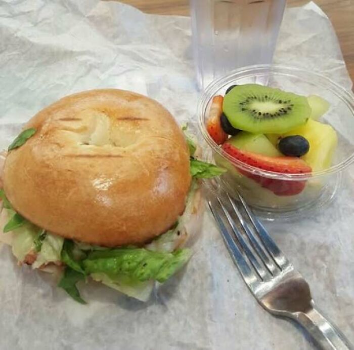 Sandwich and fruit cup with bread top resembling a staring face