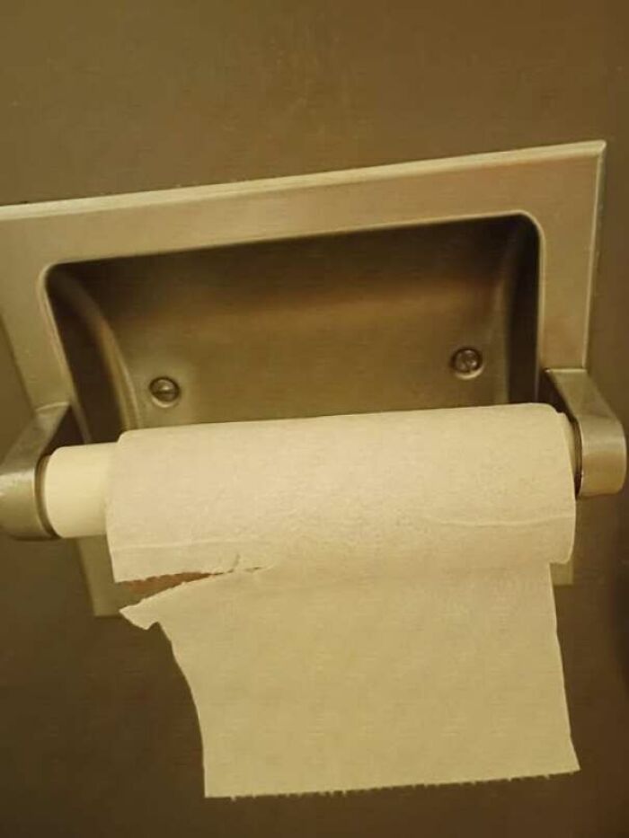 Empty toilet paper roll on holder resembling a surprised face