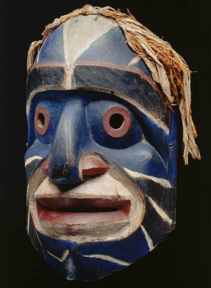 Colorful wooden tribal mask with blue and white face paint