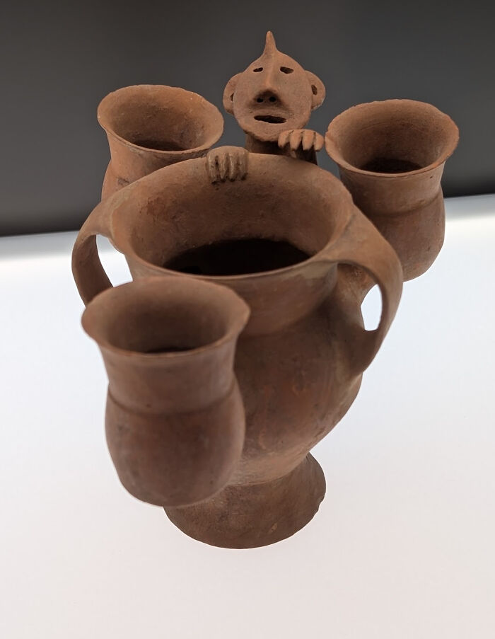 Unusual clay vessel with a small humanoid figure peeking over the rim representing strange artifacts