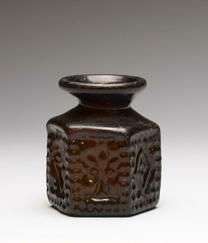 Small dark glass bottle with embossed designs, an interesting strange artifact discovery