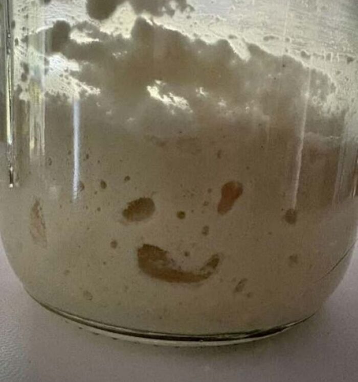 Sourdough starter in a jar resembling a smiling face