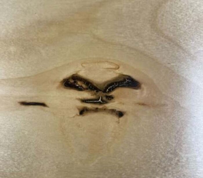 Wood knot with grain resembling an angry face