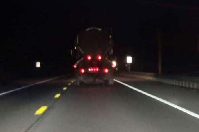 Truck taillights on road appear as staring eyes at night