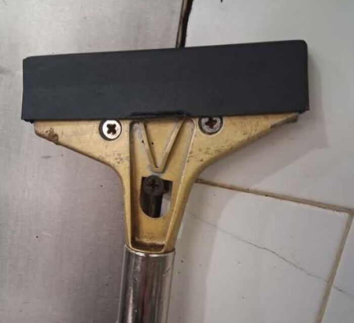 Window squeegee with metal and rubber parts forming a staring face