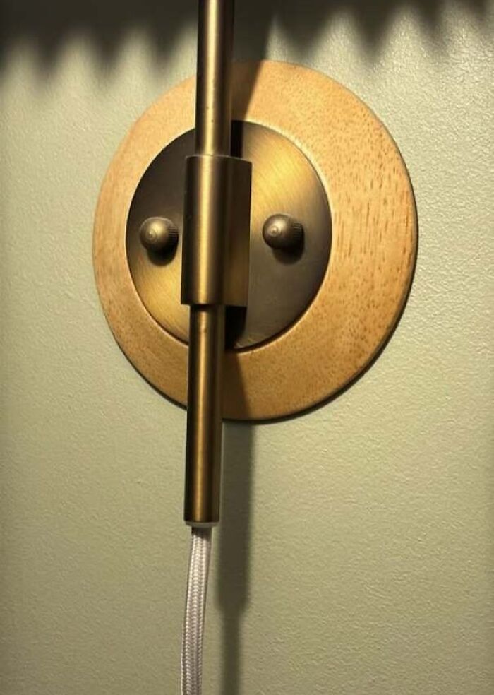 Wall light fixture with two screws resembling eyes staring