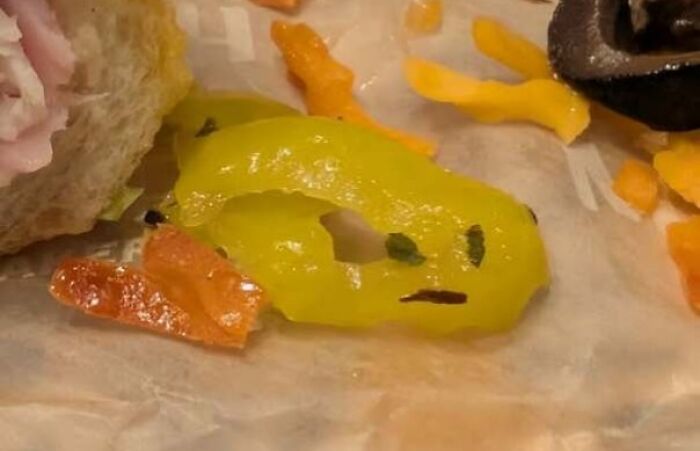 Yellow pepper slice with markings resembling a staring face