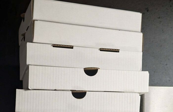 Stack of white boxes with openings resembling staring faces
