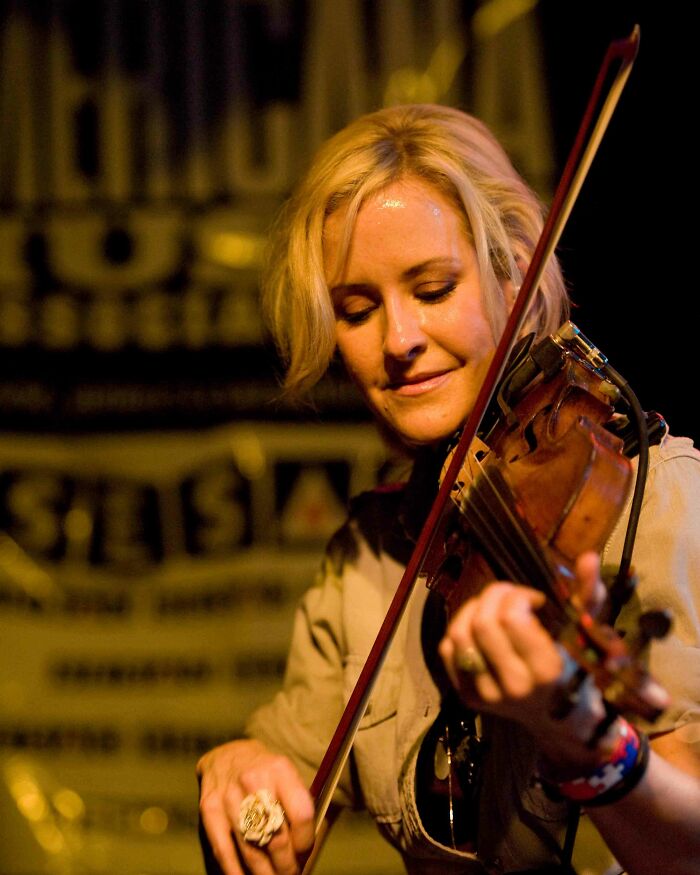 Martie Maguire plays the fiddle passionately on stage during a live concert performance