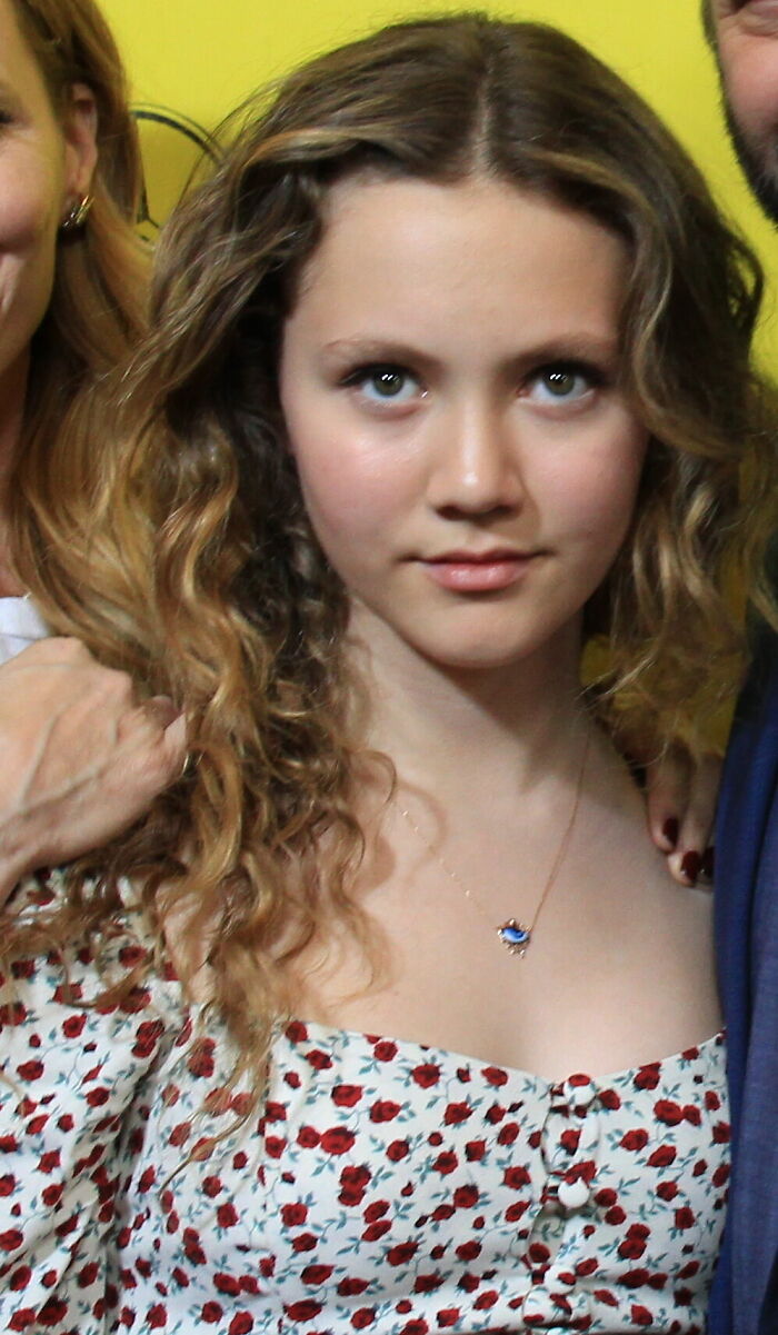 Close-up portrait of actress Iris Apatow wearing a floral print top.