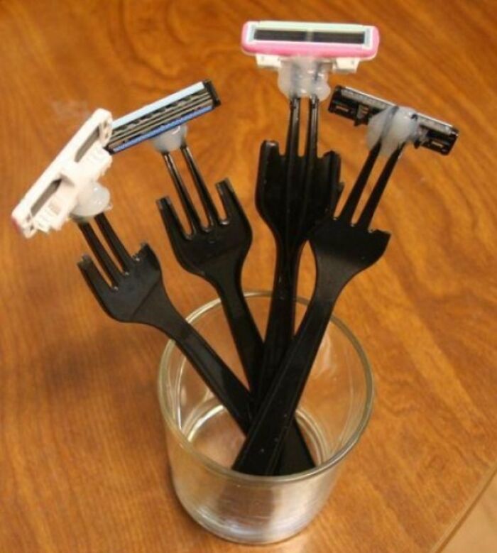 Unusual redneck fixes with razor heads attached to plastic forks resting inside a glass cup.