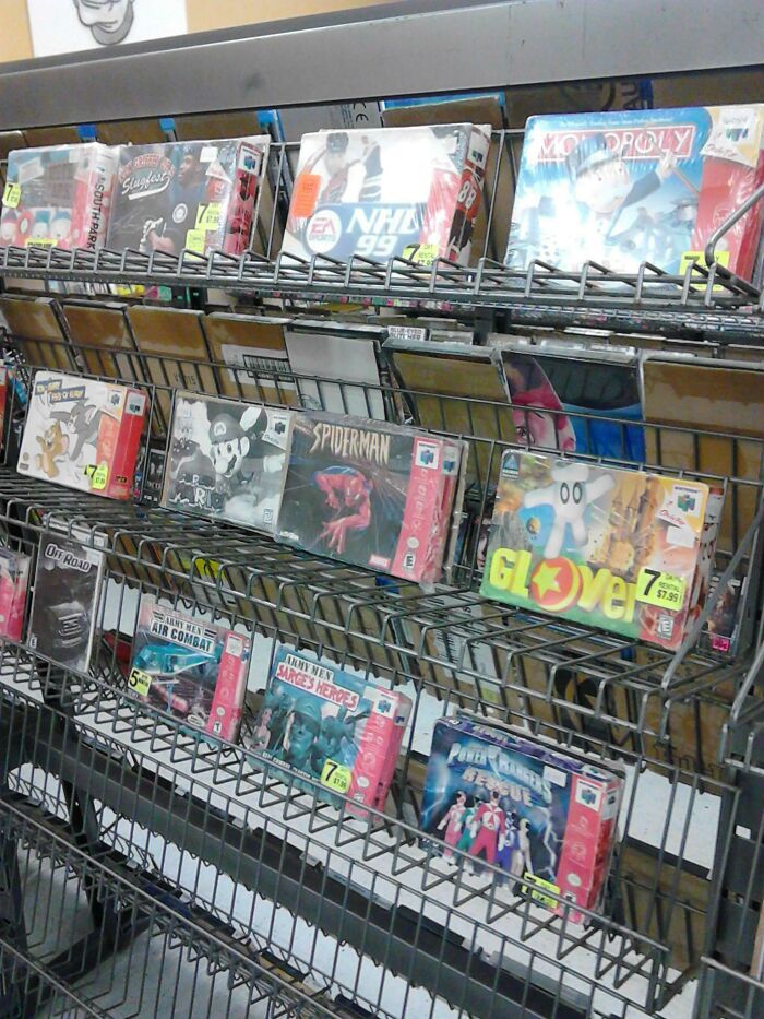 Rack of vintage Nintendo 64 game cartridges including Spider-Man and Monopoly