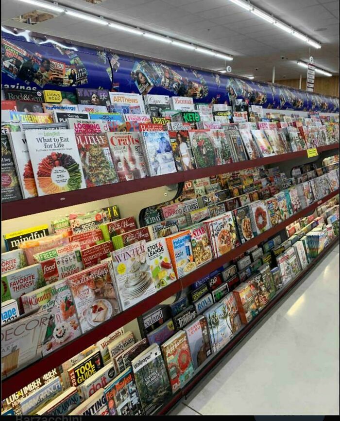 Long rack filled with various magazines on display inside a store newsstand
