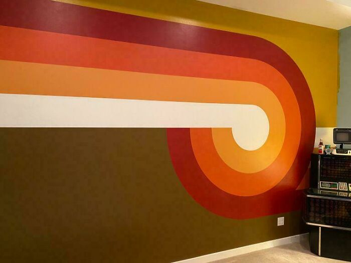 Retro 1970s wall art with brown, orange, and white stripes in a nostalgic setting