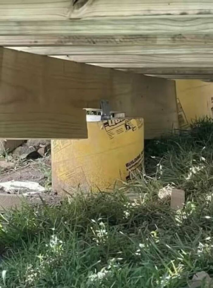 Construction fail using a plastic bucket as a support pillar under a wooden structure
