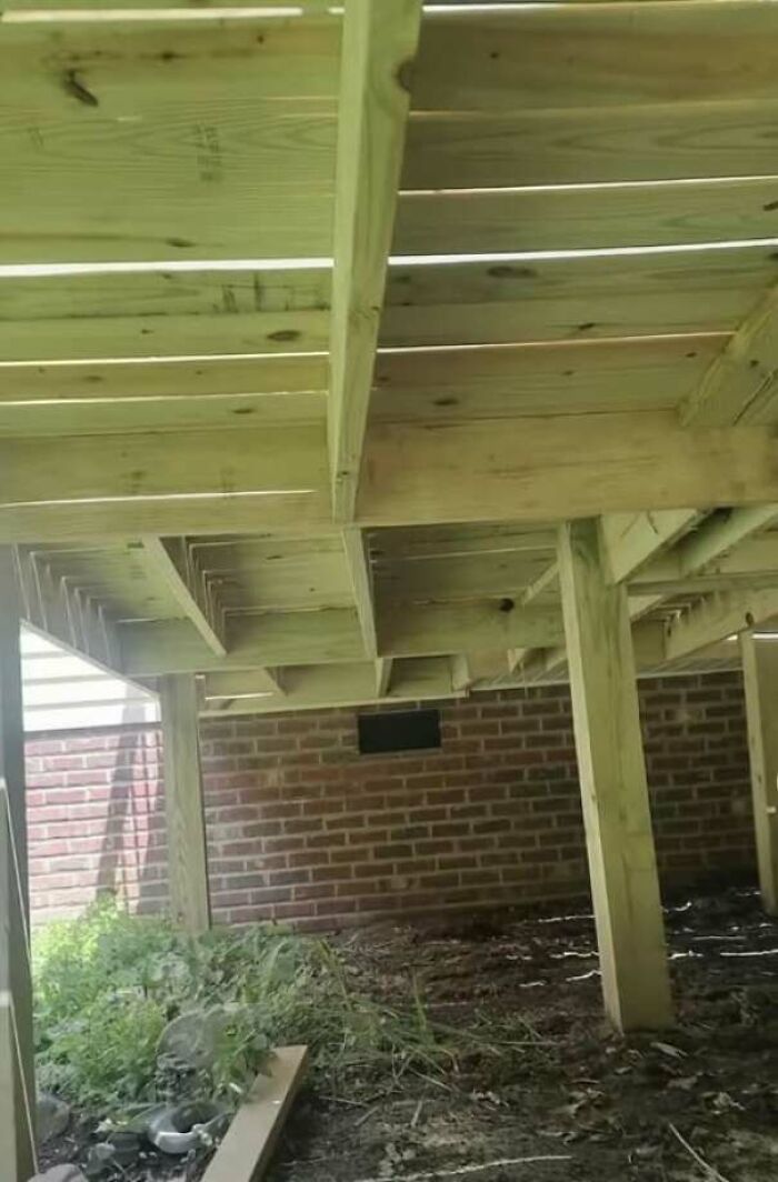 Poorly built wooden deck structure with uneven and unstable supports