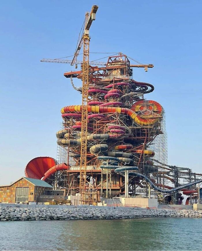 Complex waterpark construction with tangled slide tubes and crane