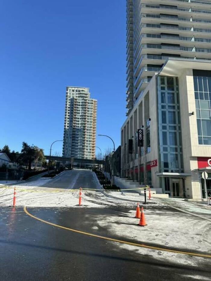 Blocked urban street with construction cones amid icy road causing safety fail