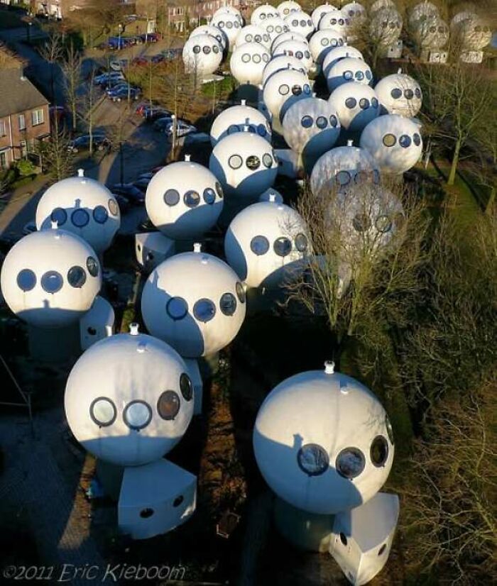 Spherical pod houses with multiple circular windows in a failed architectural design