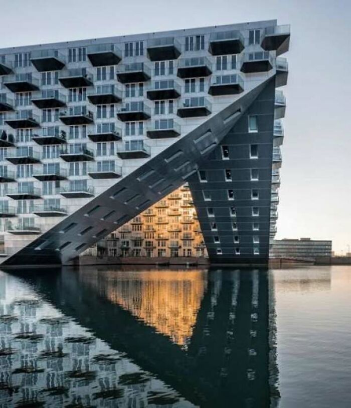 Modern building with unusual geometric structure reflected in water