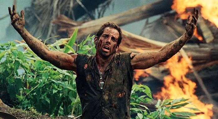 Ben Stiller covered in mud with arms raised in Tropic Thunder. Ben Stiller covered in mud with arms raised in Tropic Thunder.