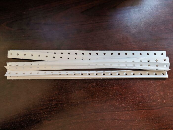 Old nostalgic computer punch cards with holes on a wooden table