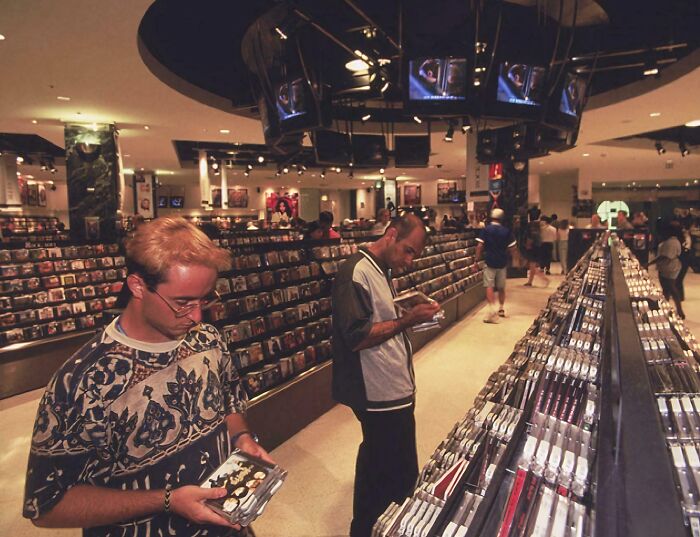 90s music store interior with customers browsing CDs in nostalgic atmosphere