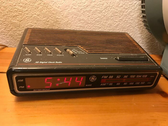 Vintage GE digital clock radio with red LED display and AM FM tuner on wood surface