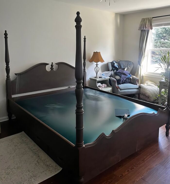 Antique nostalgic four-poster bed frame in a cozy bedroom