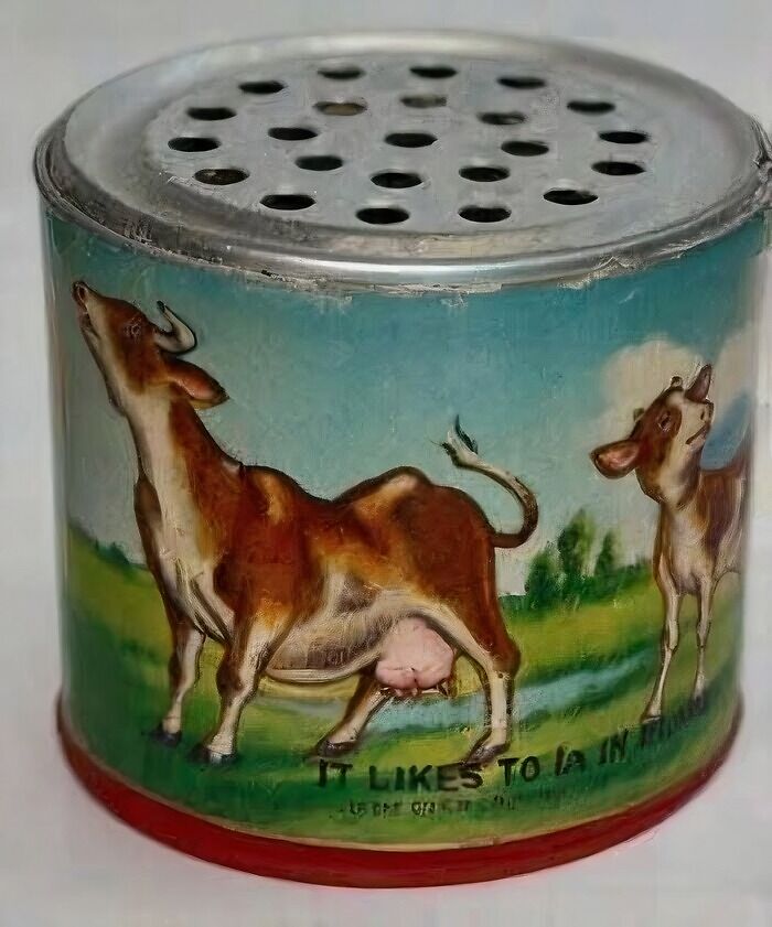 Retro metal container with painted cow illustration and holes on top