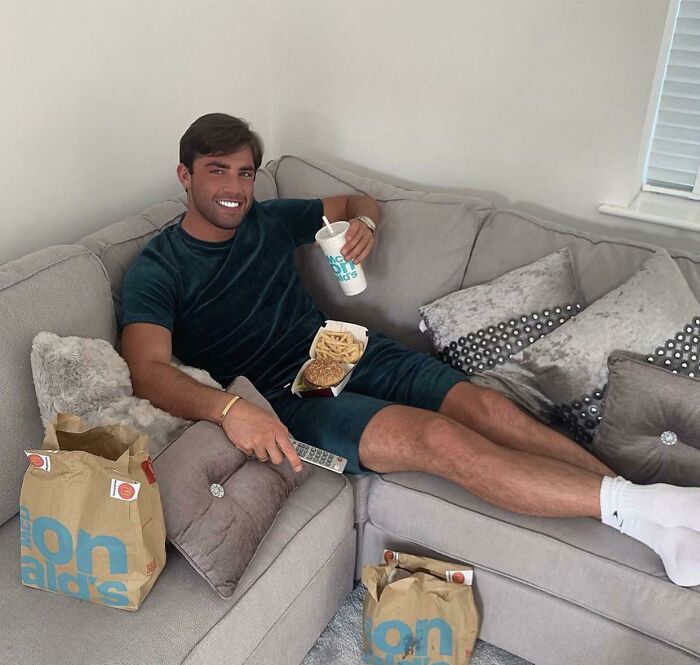Edited photo of man relaxing with fast food on couch