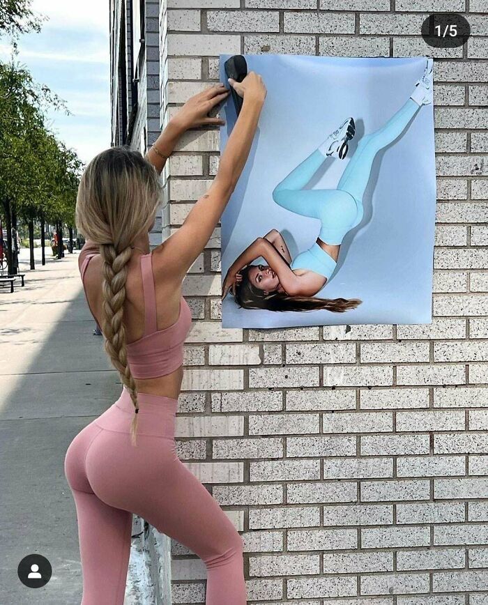 Photo of woman posting distorted fitness image on street wall with leg raised