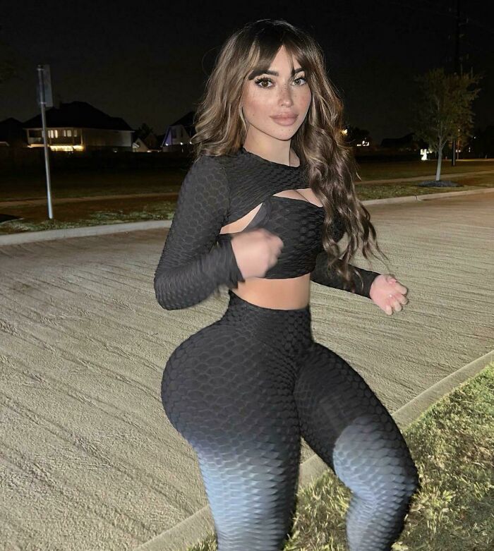 Nighttime photo edited to exaggerate waist and hip size in black outfit