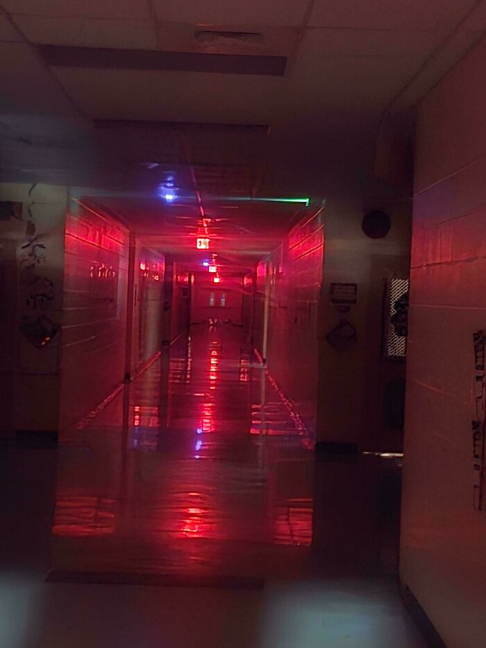 An eerie dark hallway illuminated by red glowing lights, evoking a scene from creepy photos.