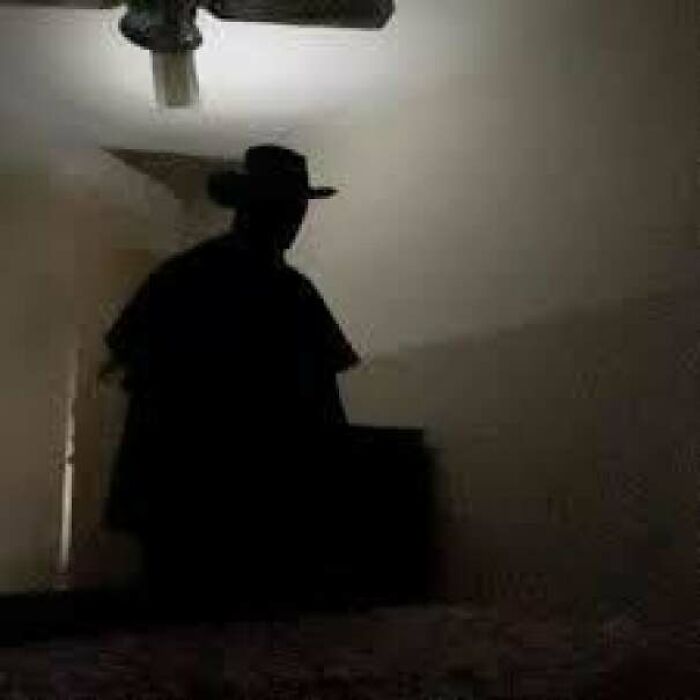 Creepy photos featuring a dark shadowed figure wearing a hat standing ominously inside a dimly lit room.