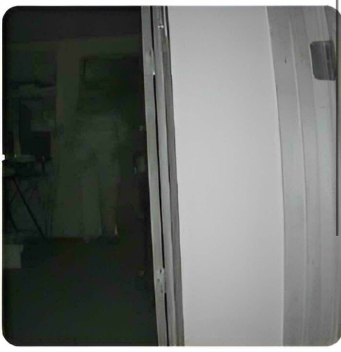 An eerie shadow figure standing in a dark doorway, captured in creepy photos.