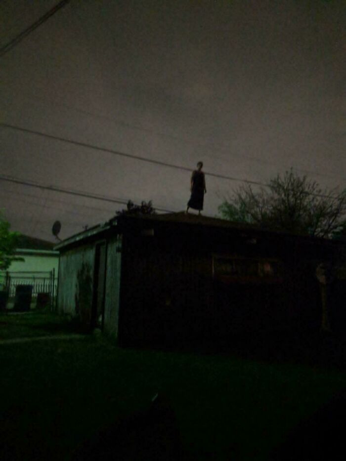 Creepy photos show a dark shadowy figure standing alone on a rooftop at night