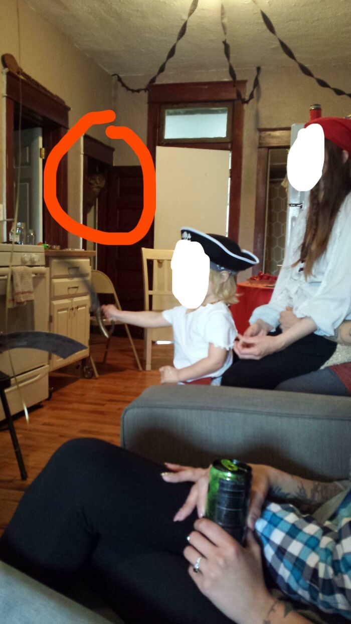 An eerie shadow highlighted in a doorway behind people in a room, capturing creepy photos and unsettling moments.