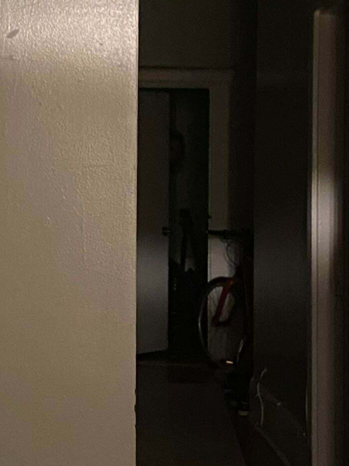 Creepy photos showing a shadowed silhouette peeking from a dark doorway down a hallway.
