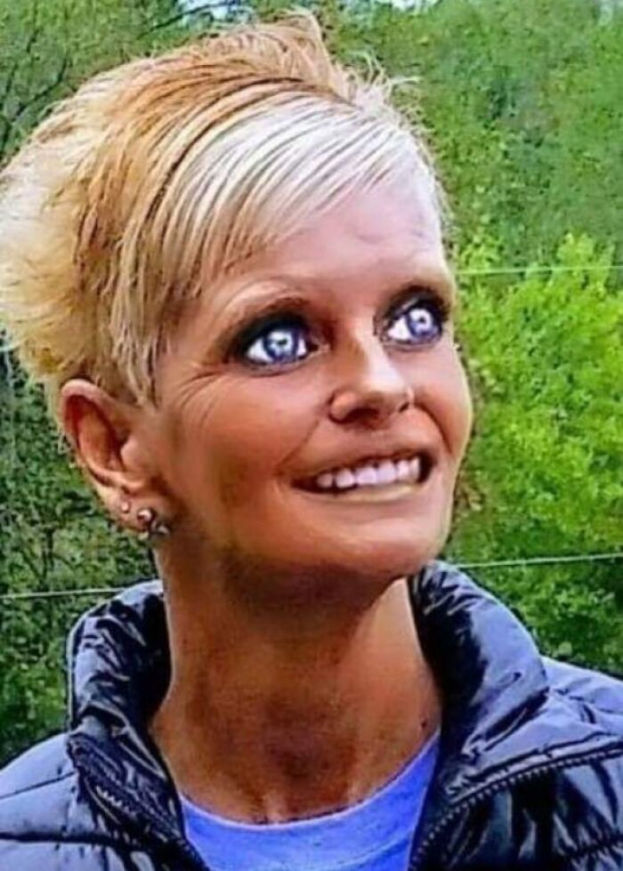 Ridiculously edited outdoor portrait of a woman with distorted eyes and smile
