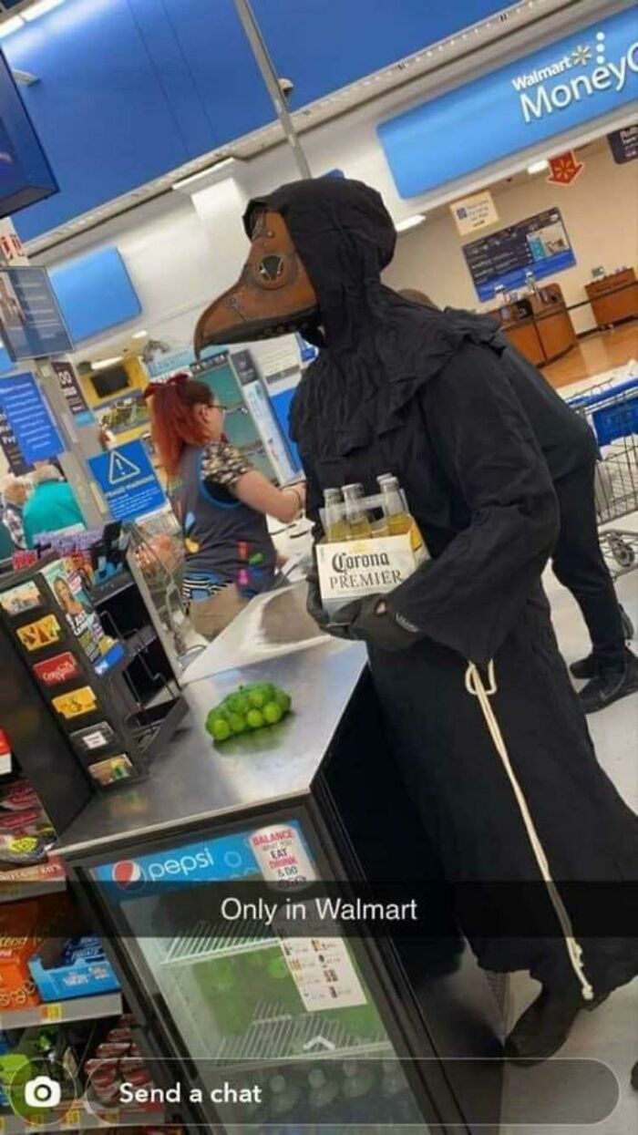 Person wearing plague doctor mask holding Corona Premier at Walmart checkout