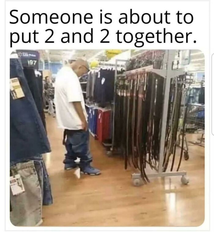 Man with sagging pants looking at belts in Walmart