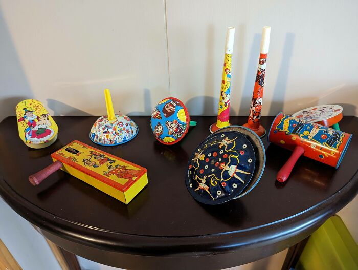 Collection of rare vintage tin noisemakers displayed on dark wooden table