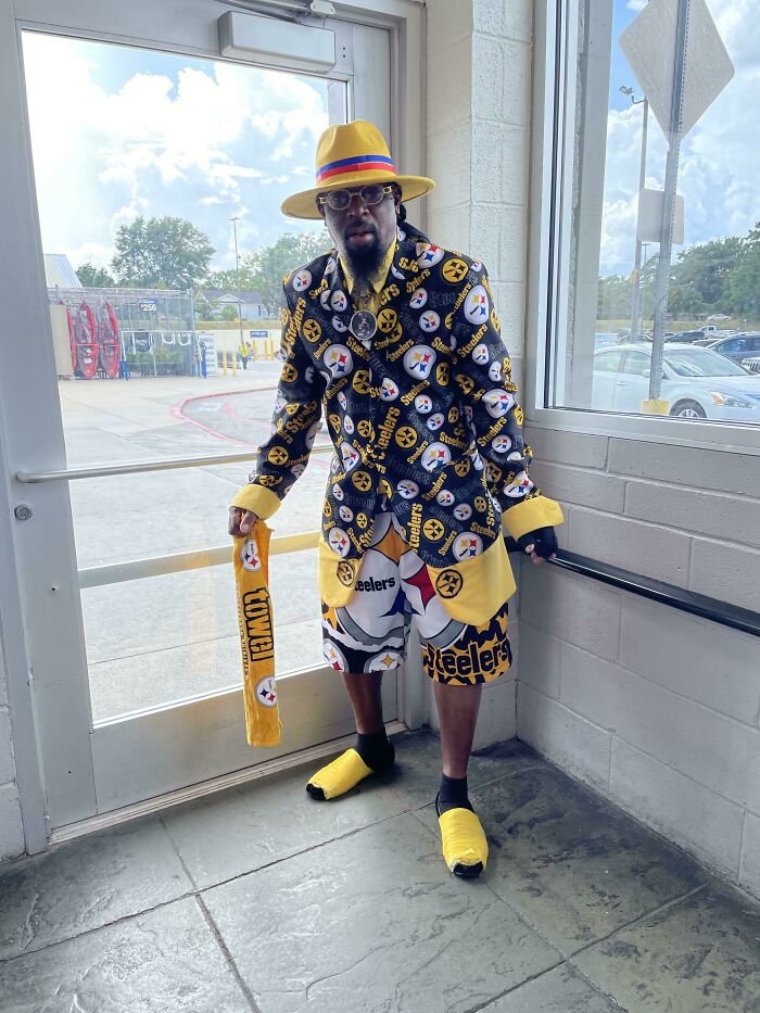 Man wearing Steelers outfit and yellow hat inside Walmart