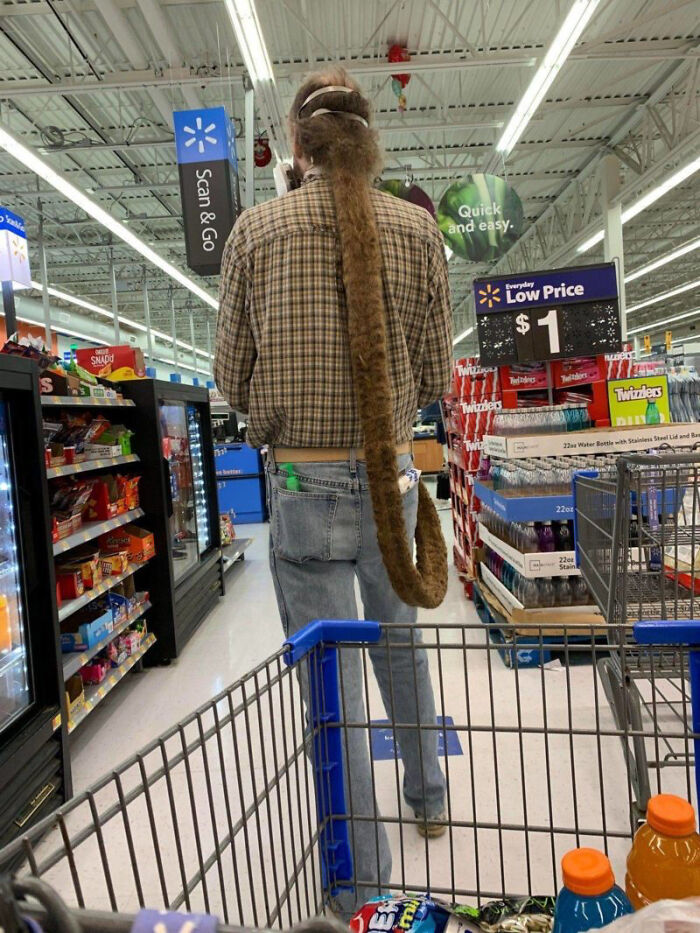 Person with long furry tail shopping inside Walmart aisle