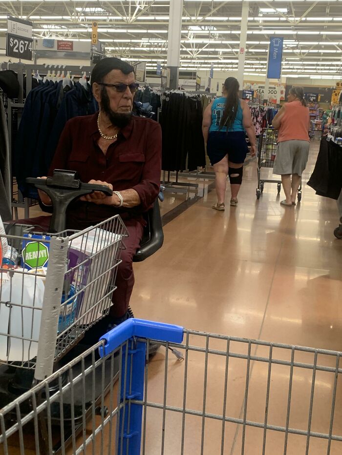 Man with beard and sunglasses riding mobility scooter inside Walmart