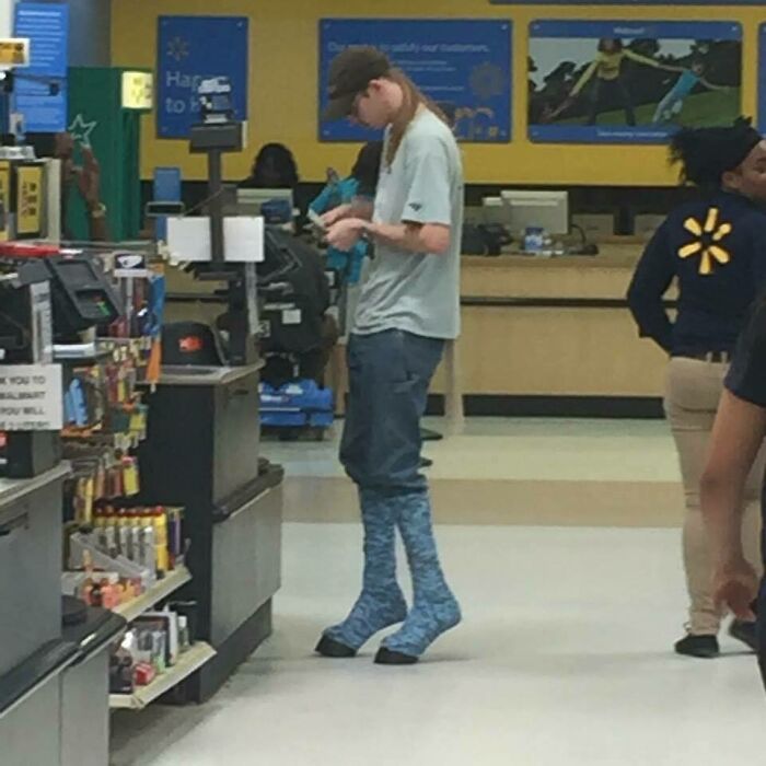 Young man in unusual tall blue socks standing at Walmart checkout